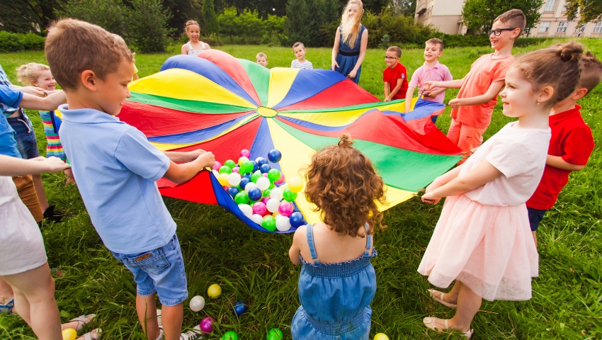 Bambini che giocano insieme felici durante un’attività di gruppo all’aperto